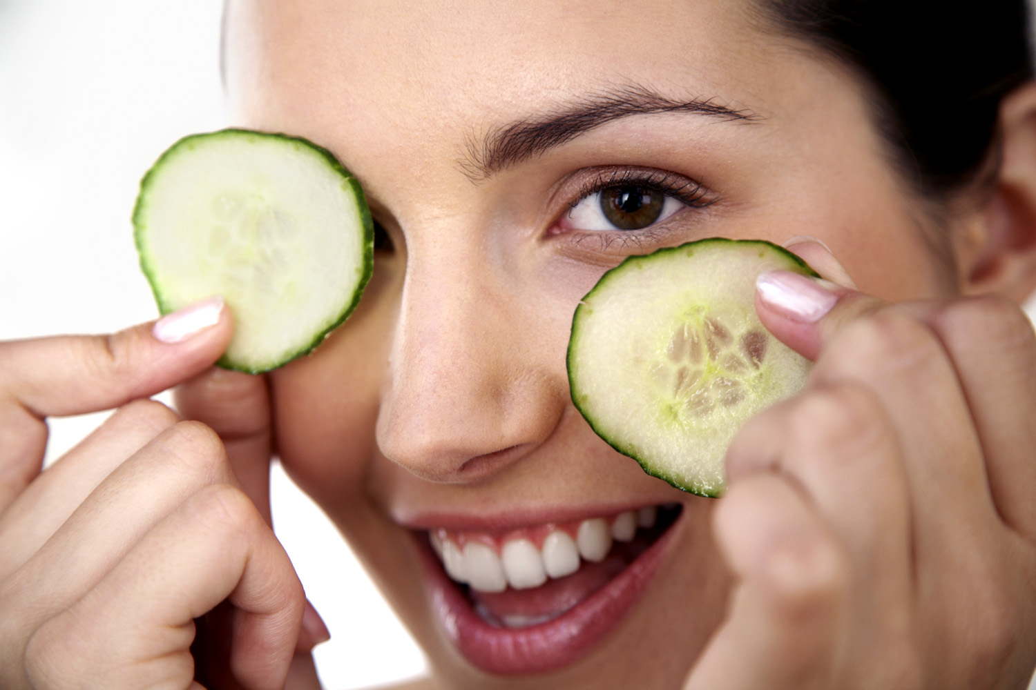 Woman Holding Cucumber Slices over Eyes
